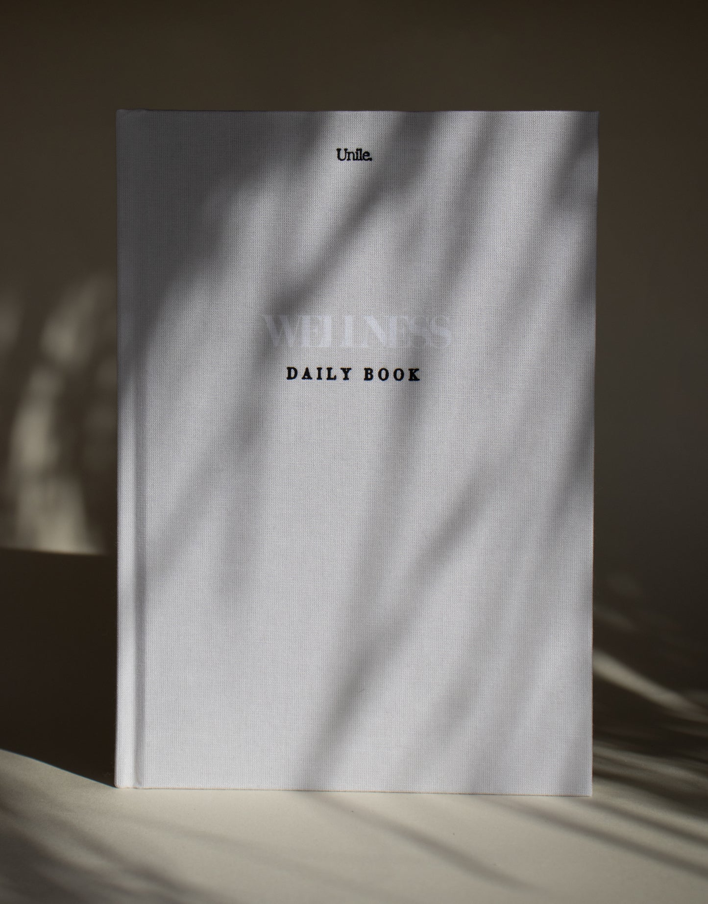 Wellness book Unile carnet bien-être minimaliste journaling guidé bien-être féminin, livre bien-être avec jeux d'ombres.