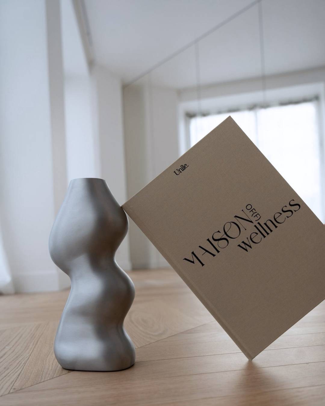 Le book Maison Of(f) Wellness posé sur une silhouette féminine.