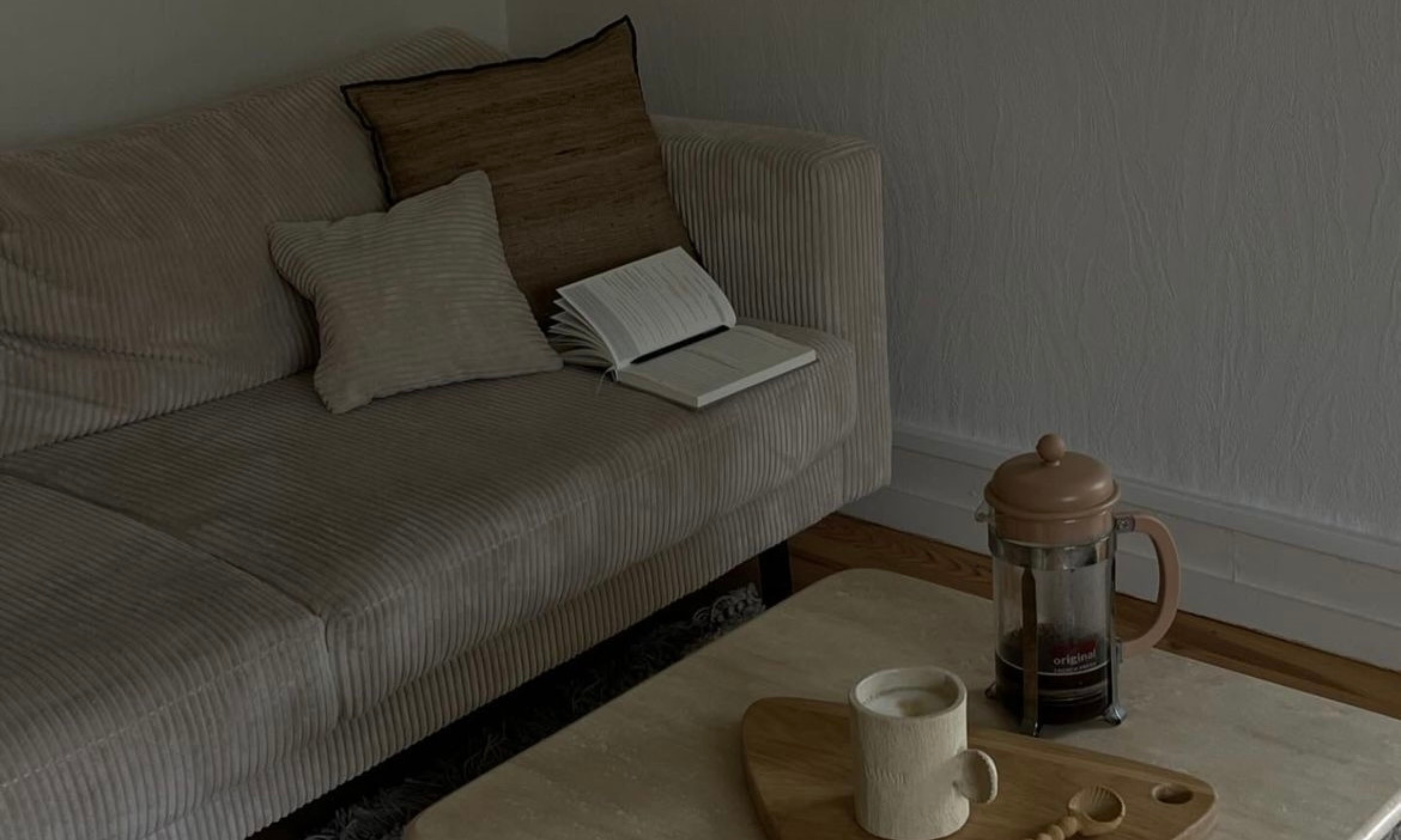Carnet de journaling ouvert sur un canapé en velours beige dans une ambiance cosy et chaleureuse.