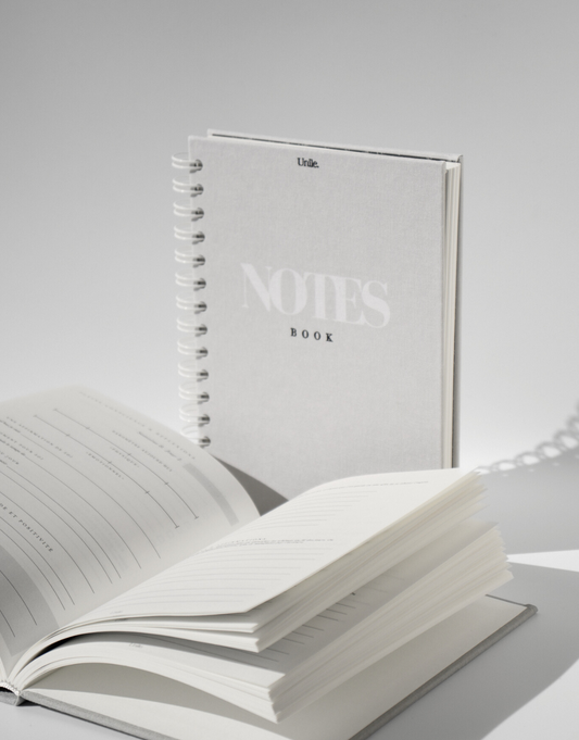 LE duo Notebook & Journal - unile.selfcare carnet de notes et journaling posés sur fond blanc avec jeux d'ombres.